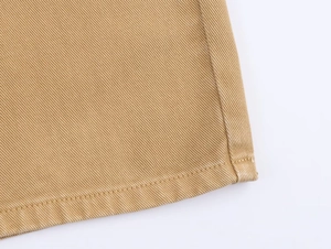 Detailed macro view of khaki twill fabric texture and durable hem stitching for trousers