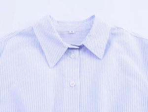 Detail of blue and white striped shirt collar with white buttons and size S label