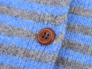 Close-up of blue and grey striped knit sweater with textured brown button detail