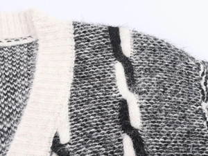 Gros plan sur la maille contrastée et les fibres de mohair douces d'un gilet à col en V