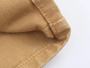 Macro detail of khaki twill denim fabric with reinforced stitching and textured weave