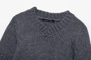 Macro shot of dark grey chunky knit sweater neckline featuring ribbed texture and inner label