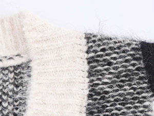Détail d'un pull en maille color-block montrant la texture épaisse et le bord-côte
