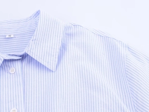 Detail view of the collared striped shirt showing blue and white fabric and a size S tag