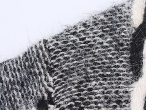 Vue macro du cardigan en maille grise montrant la texture du tissu et le tissage fin