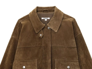 Detail shot of brown suede jacket collar with brand label and metallic button fasteners