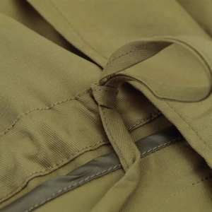 Close-up of khaki parka jacket showing waist drawstring knot and cotton twill fabric texture