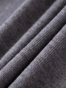 Detailed macro view of the soft grey knit fabric texture and fine knitting craftsmanship