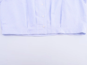 Close-up of blue and white striped shirt with three white buttons and neat hemline detail