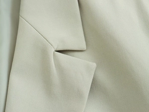 Détail du revers et de la texture sergé d'un blazer à manches longues pour femme