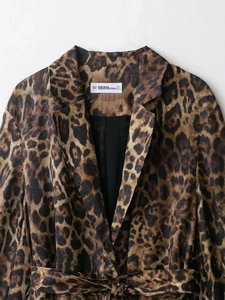 Detail of leopard print blazer with notched lapel and branded neck label showing size