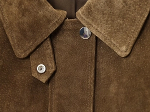 Detail of brown faux suede bomber jacket showing silver metal snaps and texture