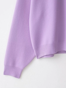 Detail view of purple ribbed knit texture on the cuffs and hem of the stylish sweatshirt