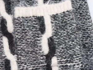 Gros plan macro sur la maille à poils longs montrant la texture contrastée du mohair