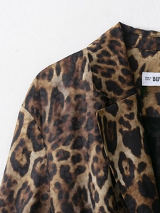 Detail of leopard print blazer showing collar stitching and inner woven neck label texture