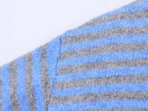 Detailed view of the fuzzy blue and grey horizontal striped knit fabric texture