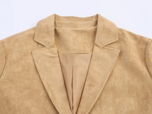 Detail of classic notched lapel and shoulder of a camel suede long coat for women