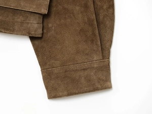 Detail of the fine stitching and premium brown suede texture on the jacket cuff