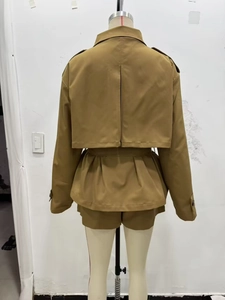 Vista posteriore di completo trench corto kaki e pantaloncini con dettaglio mantella