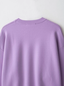 Detailed close-up of lavender ribbed knit sweater neckline and shoulder stitching texture