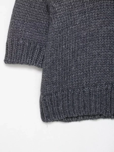 Detailed macro view of dark grey thick knit sweater cuffs with ribbed texture
