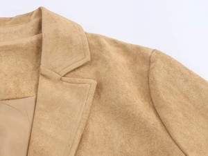 Close-up detail of khaki faux suede texture on lapel and shoulder of a fashion coat
