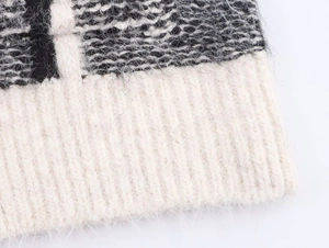 Détail de la maille mohair douce et poignets côtelés au design contrasté noir et blanc