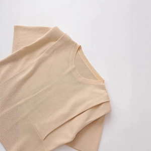 Chic beige short sleeve knit top with padded shoulders and a classic round neckline
