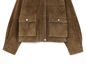 Detail of brown suede jacket showing flap pockets with silver metallic snap buttons