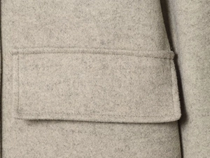 Detailed close-up of the flap pocket with premium stitching on wool blend jacket
