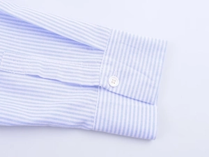 Close-up of blue and white striped shirt cuff with white button and neat stitching