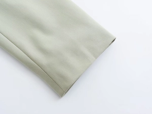 Détail de la manche en tissu tissé vert sauge avec couture nette et texture de qualité