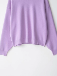 Detail view of the soft purple ribbed knit texture on the hem and cuffs of the sweater