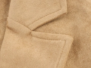Detail of high-quality camel faux suede long coat featuring classic wide notched lapels