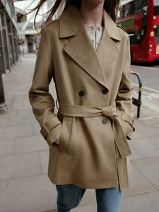Classic khaki double-breasted trench coat detail with waist belt and lapel collar
