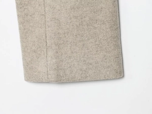 Close-up of premium light grey wool fabric showing cuff details and thick texture