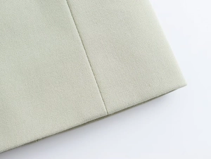 Vue macro du tissu sergé vert clair de haute qualité et coutures uniformes du blazer