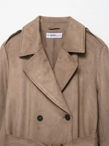 Detail of the brown faux suede trench coat featuring double-breasted buttons and waist belt