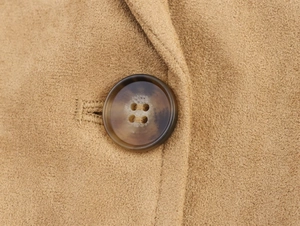 Detail shot of the amber-textured button and soft faux suede fabric on this coat