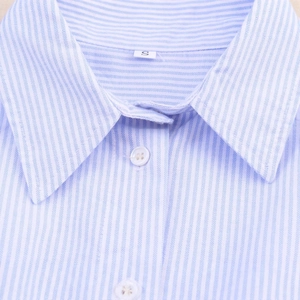 Close-up of blue striped shirt collar with white buttons and size S label detail