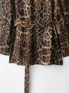 Detail of leopard print suit jacket showing smooth texture and matching waist belt tie