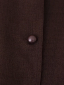 Detailed close-up of a brown waistcoat button featuring fine diagonal twill fabric texture