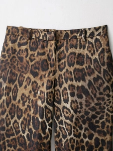 Close-up of leopard print trousers with waist loops and high-waisted tailored details