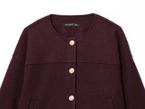Detailed view of burgundy wool jacket featuring textured fabric and embossed gold buttons