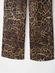Detailed close-up of leopard print satin fabric with straight-cut trouser leg design