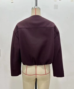 Detailansicht der Rückseite einer dunkelvioletten Jacke mit goldenem Knopf auf Schneiderpuppe