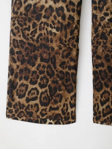 Close-up of leopard print trousers featuring straight leg cut and fluid drape fabric