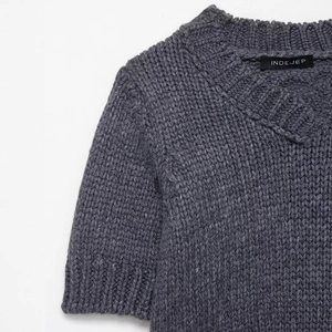 Dark grey short sleeve knit sweater featuring a V-neckline and premium ribbed texture