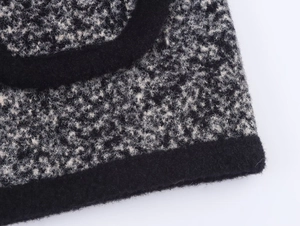 Dettaglio della trama in maglia bianco e nero con bordo rifinito in nero profondo