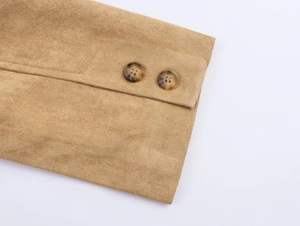 Macro view of brown faux suede coat cuff featuring two tortoise-patterned round buttons
